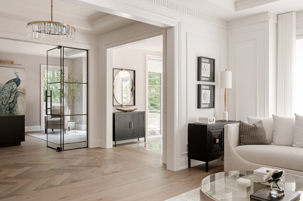 Large transitional light wood floor, tray ceiling and wall paneling hallway photo in Toronto with white walls
