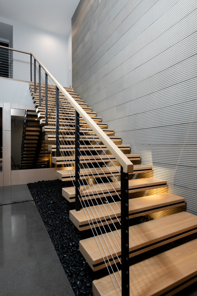 На фото: огромная прямая лестница в стиле модернизм с деревянными перилами с