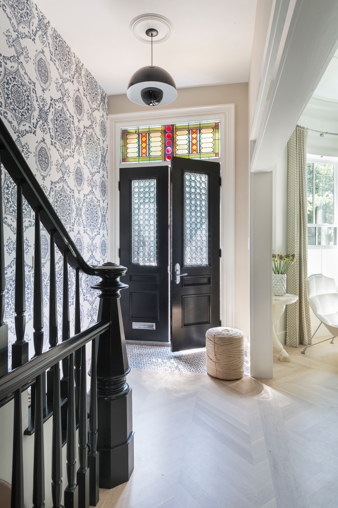 Photo of an eclectic entryway in Boston with light hardwood floors, a double front door and a black front door.