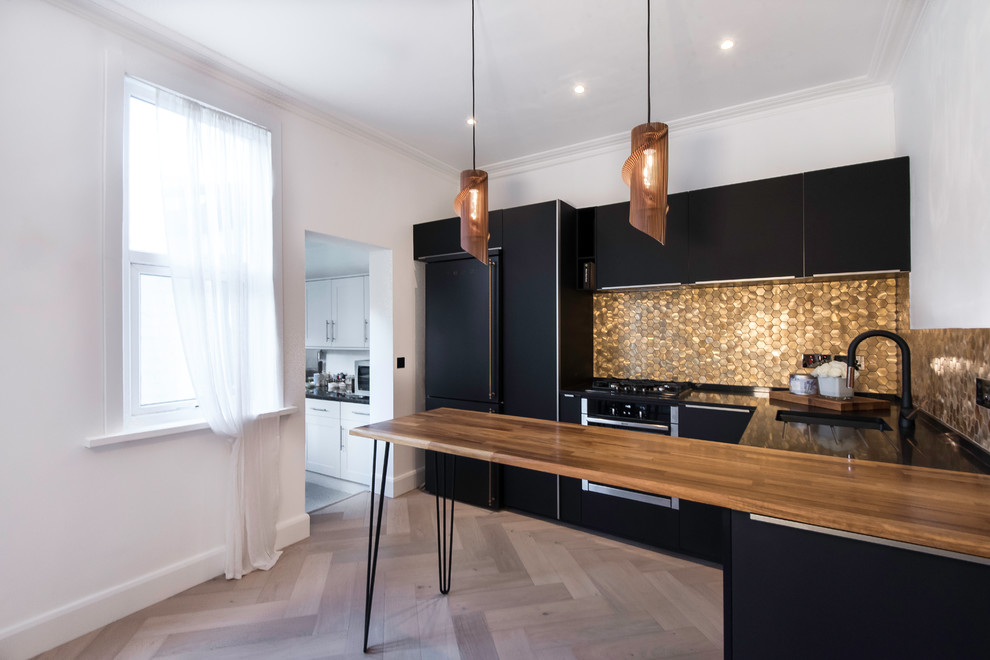 Inspiration for a mid-sized contemporary u-shaped eat-in kitchen in London with flat-panel cabinets, black cabinets, quartzite benchtops, metallic splashback, metal splashback, black appliances, light hardwood floors, a peninsula and multi-coloured floor.