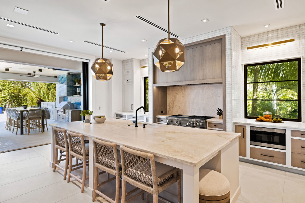 Mid-sized contemporary galley eat-in kitchen in Grand Rapids with an undermount sink, recessed-panel cabinets, white cabinets, limestone benchtops, beige splashback, limestone splashback, black appliances, ceramic floors, with island, beige floor and beige benchtop.