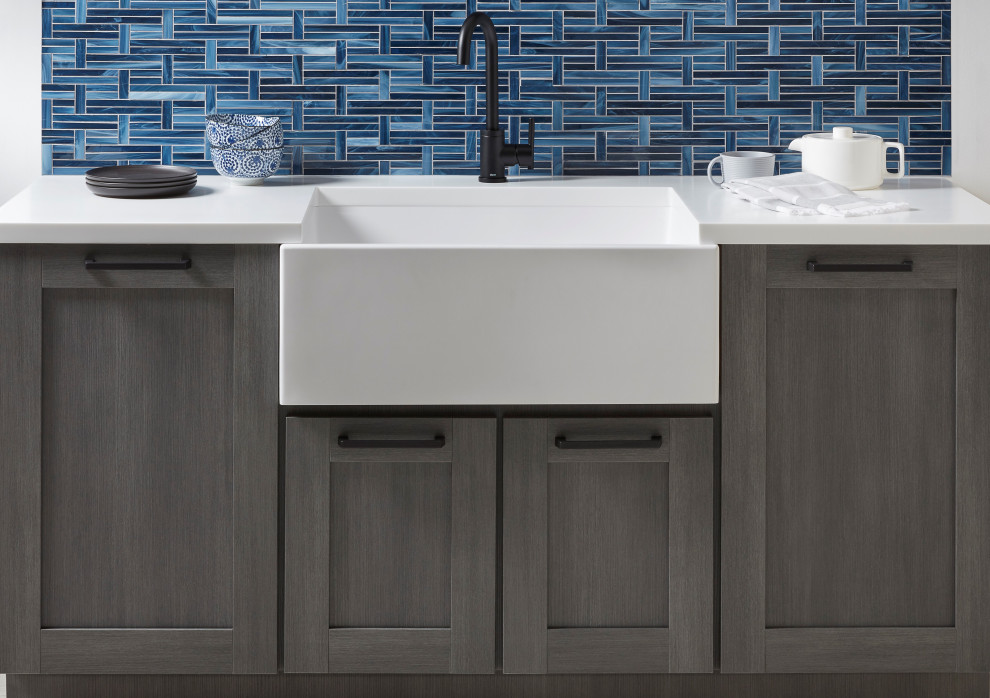 Eat-in kitchen - contemporary eat-in kitchen idea in Austin with shaker cabinets, no island, a farmhouse sink, solid surface countertops, blue backsplash and white countertops