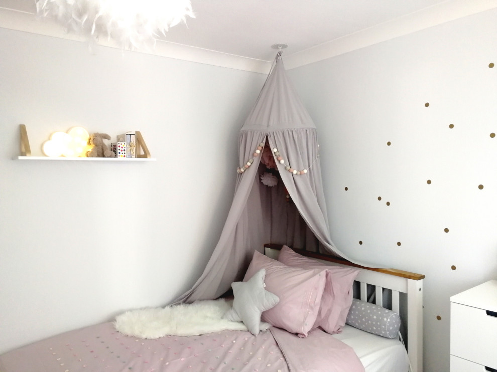 Imagen de habitación de niña de 4 a 10 años moderna pequeña con paredes grises y suelo de madera clara
