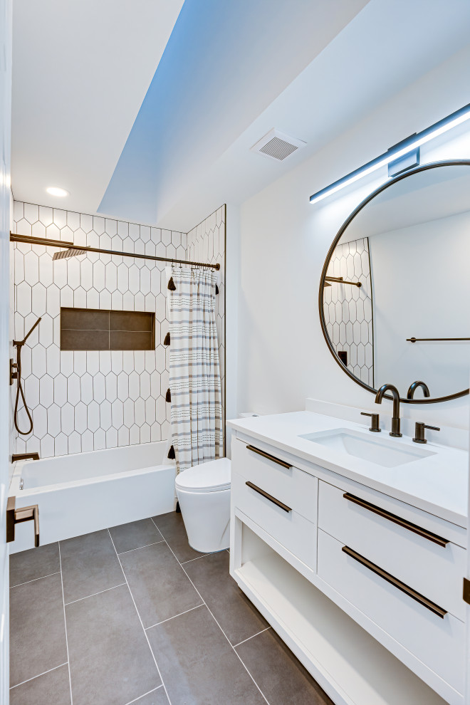 Idee per una piccola stanza da bagno moderna con vasca da incasso, doccia alcova, piastrelle bianche, pareti bianche, pavimento con piastrelle in ceramica, pavimento nero, doccia con tenda e top bianco
