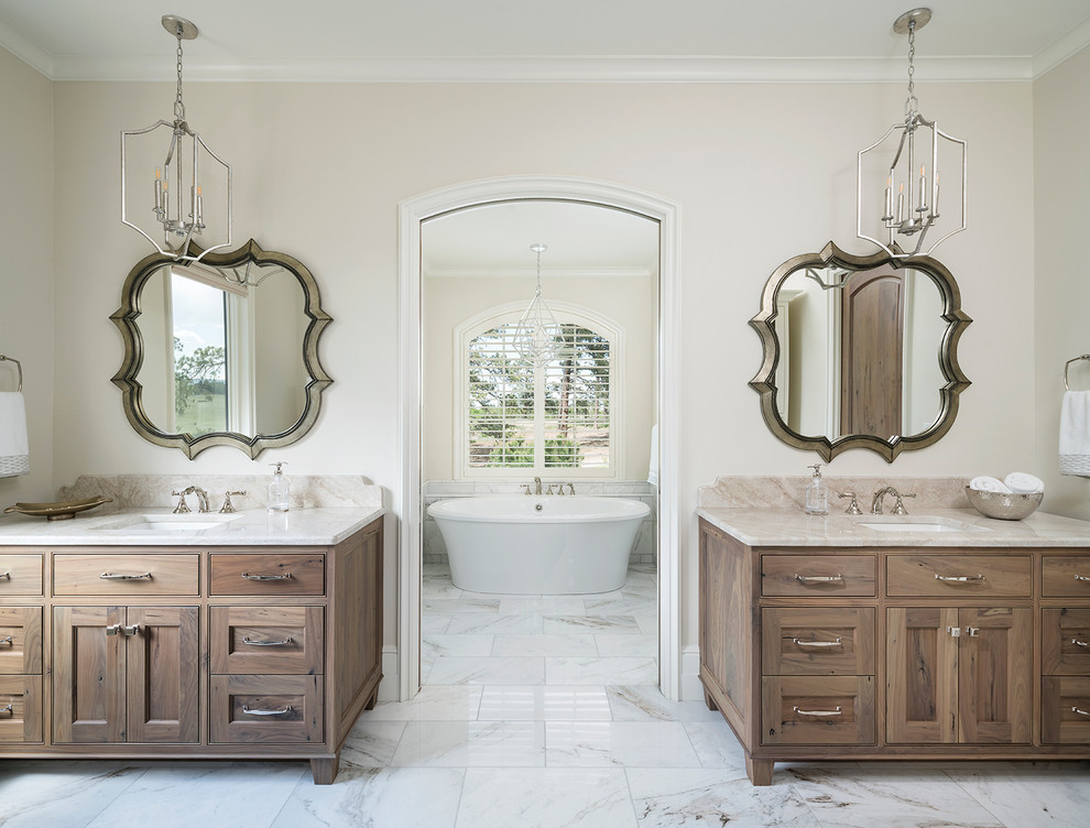 Design ideas for a transitional master bathroom in Denver with recessed-panel cabinets, medium wood cabinets, a freestanding tub, beige walls, an undermount sink, white floor and beige benchtops.