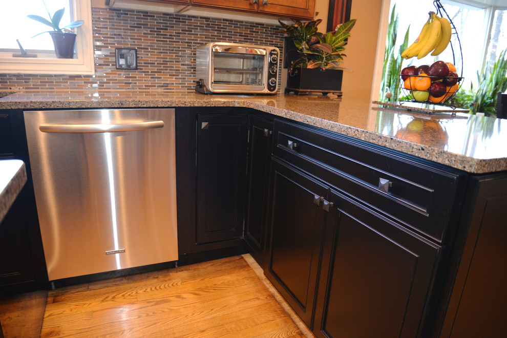 Open concept kitchen - mid-sized transitional u-shaped light wood floor open concept kitchen idea in Grand Rapids with an undermount sink, recessed-panel cabinets, black cabinets, quartzite countertops, multicolored backsplash, glass tile backsplash, stainless steel appliances and an island