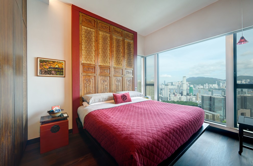 This is an example of a mid-sized asian master bedroom in Hong Kong with white walls and dark hardwood floors.