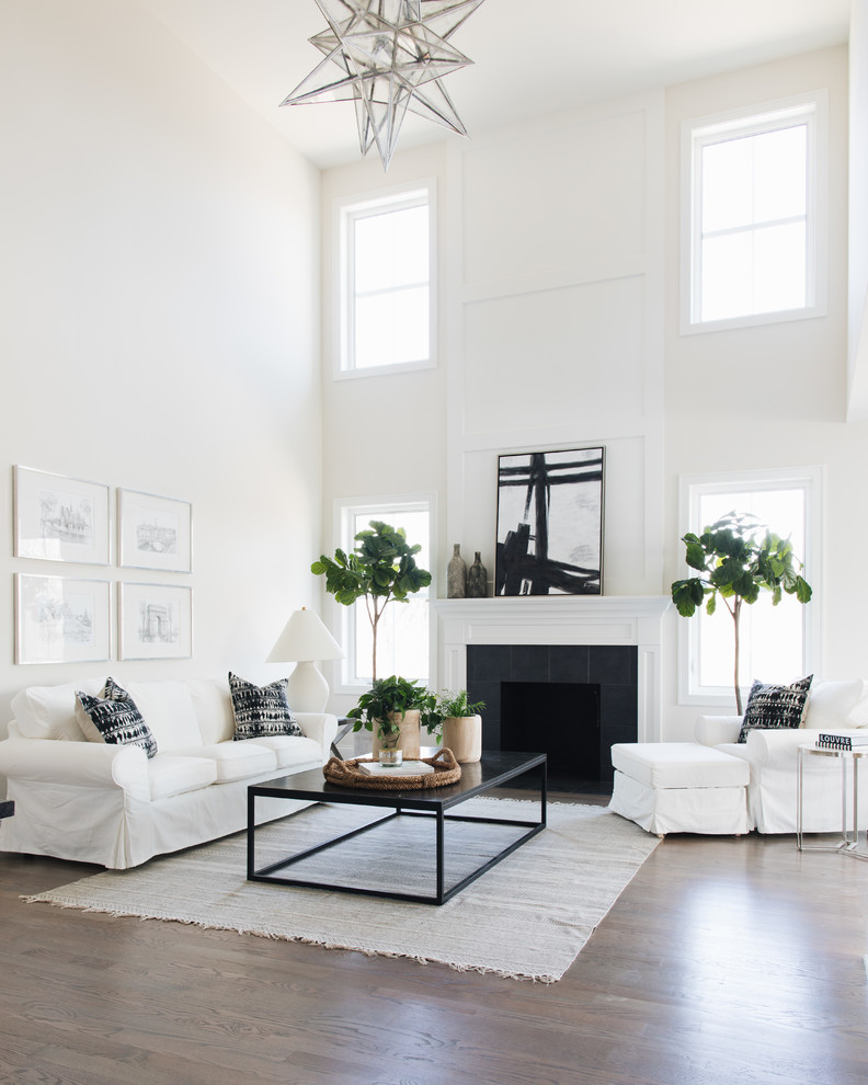 Photo of a transitional open concept living room in Chicago with white walls, a standard fireplace and a tile fireplace surround.
