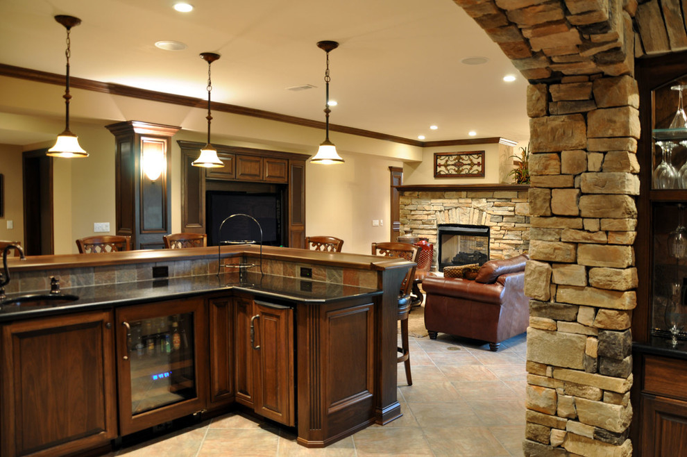 Traditional walk-out basement in Cincinnati with beige walls, porcelain floors, a standard fireplace and a stone fireplace surround.