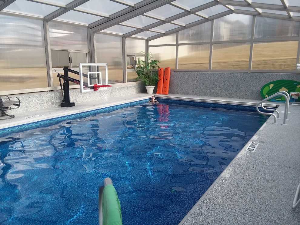 This is an example of a large contemporary indoor rectangular lap pool in Other with concrete slab.