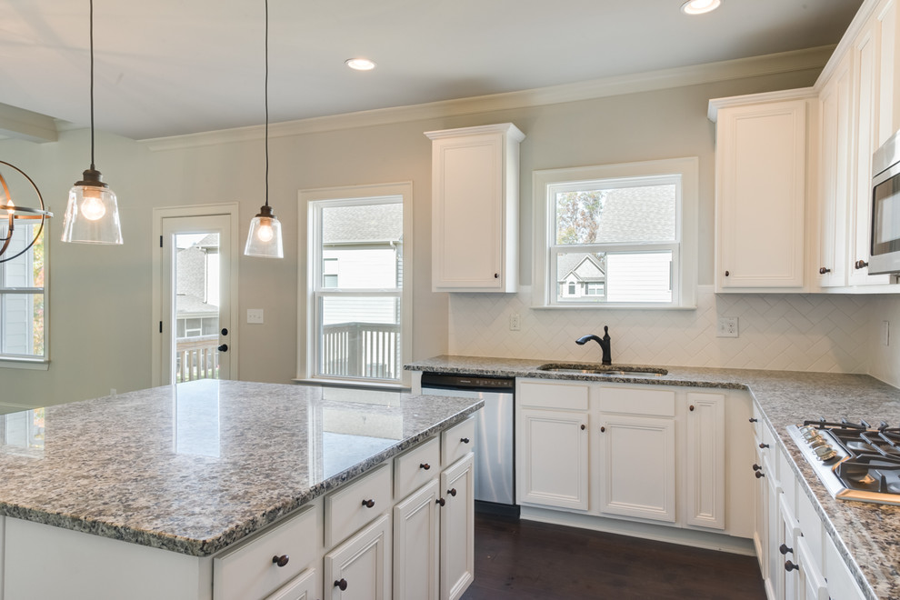 Inspiration for a large transitional u-shaped dark wood floor and brown floor eat-in kitchen remodel with an undermount sink, recessed-panel cabinets, white cabinets, granite countertops, white backsplash, subway tile backsplash, stainless steel appliances and an island