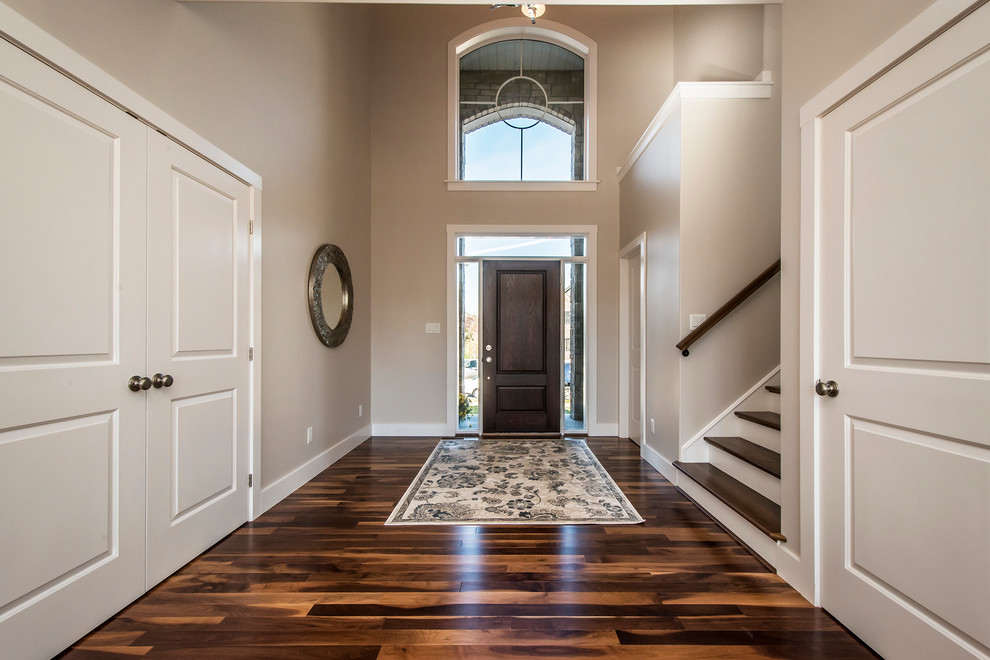 Mid-sized transitional dark wood floor and brown floor front door photo with beige walls and a dark wood front door