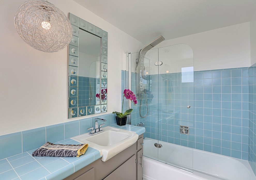 This is an example of a mid-sized midcentury master bathroom in Los Angeles with flat-panel cabinets, grey cabinets, an alcove tub, a corner shower, blue tile, porcelain tile, white walls, concrete floors, a wall-mount sink and tile benchtops.