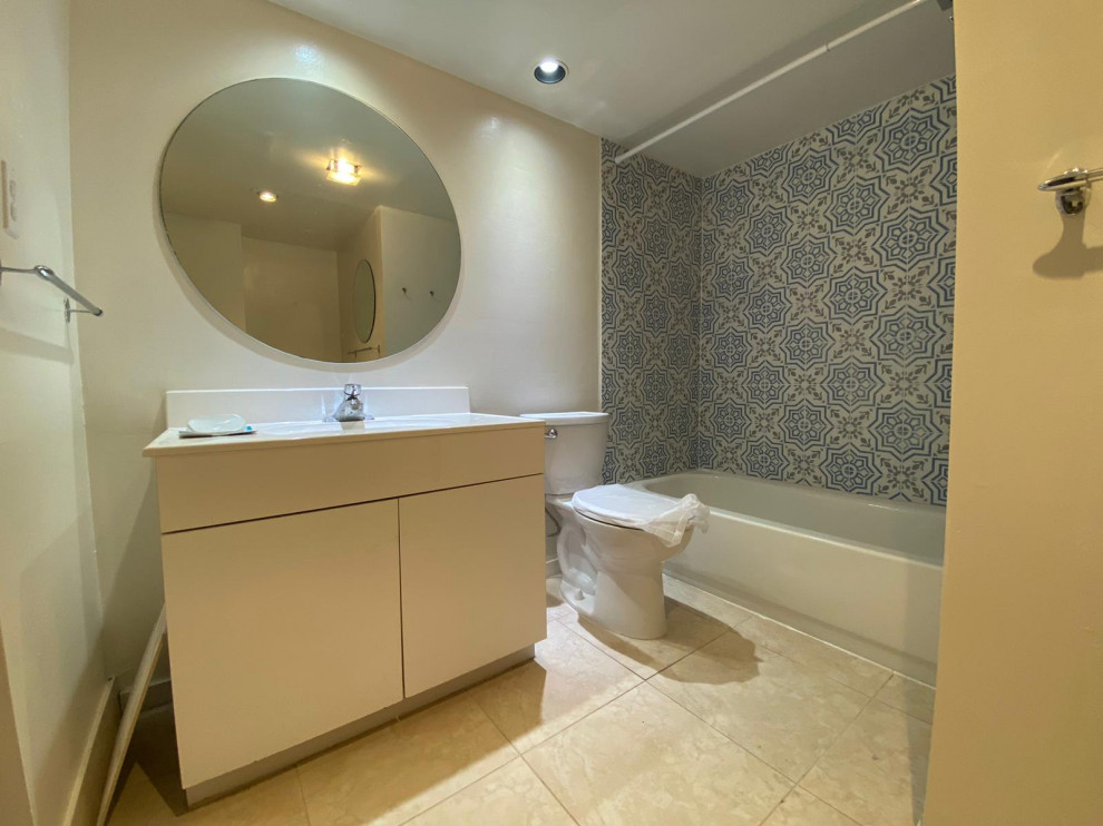Inspiration for a small modern master blue tile and porcelain tile porcelain tile, beige floor and single-sink alcove bathtub remodel in Miami with flat-panel cabinets, white cabinets, a one-piece toilet, beige walls, a drop-in sink, solid surface countertops, white countertops and a freestanding vanity