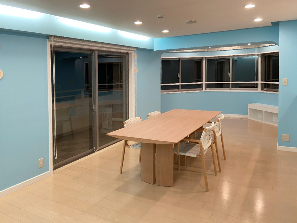 Modelo de salón abierto exótico de tamaño medio sin chimenea y televisor con paredes azules, suelo de madera en tonos medios, suelo beige y papel pintado