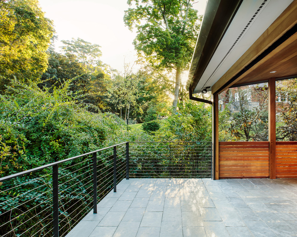 Design ideas for a modern backyard screened-in verandah in New York with tile and a roof extension.