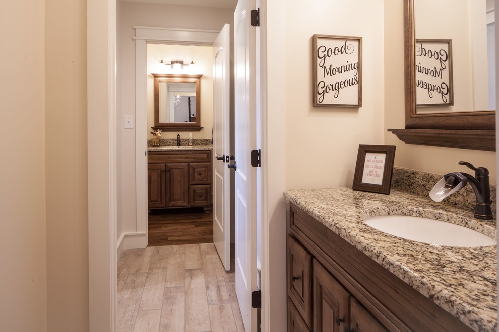 Freestanding bathtub - mid-sized transitional master beige tile and stone tile ceramic tile and beige floor freestanding bathtub idea with raised-panel cabinets, medium tone wood cabinets, beige walls, an undermount sink, granite countertops and a hinged shower door