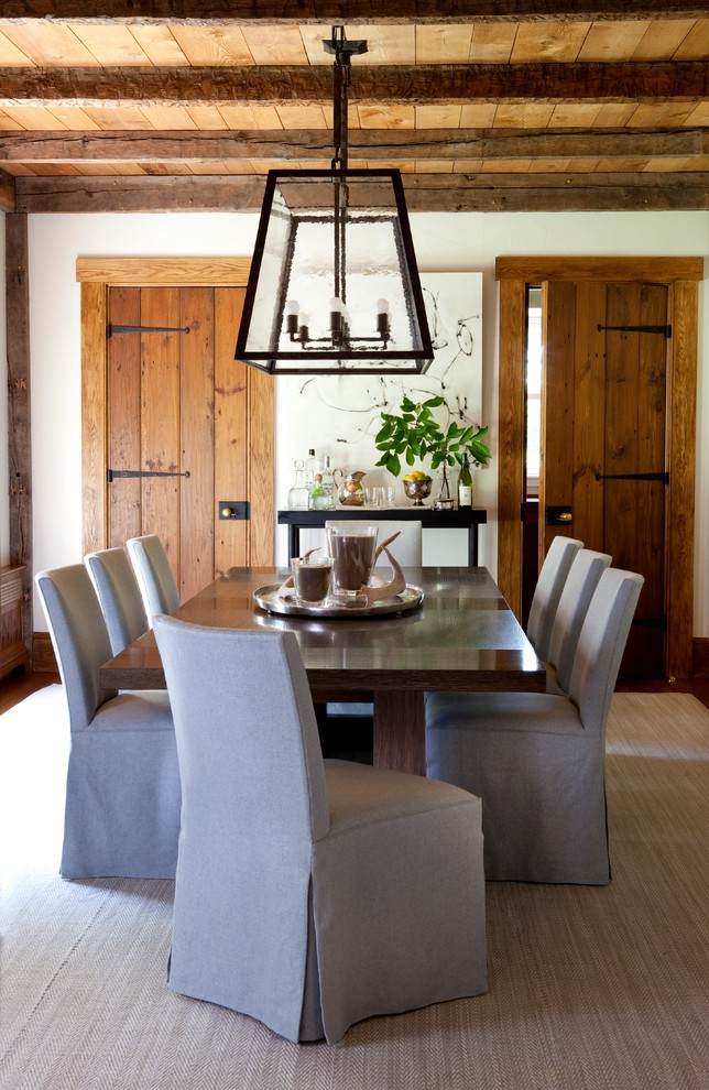 This is an example of a country separate dining room in New York with white walls.