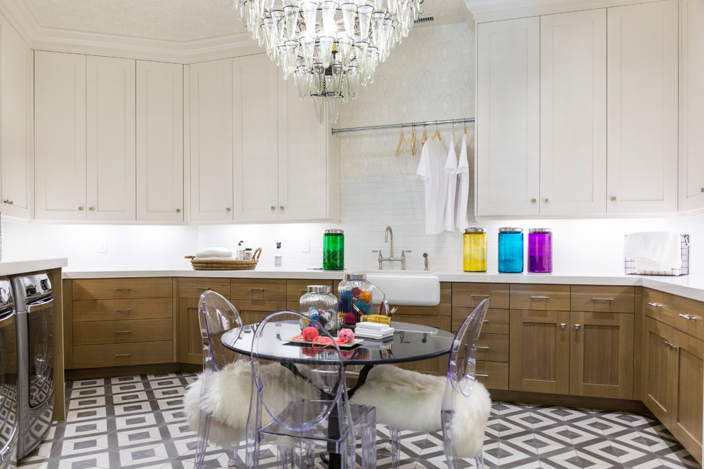 Laundry room - large transitional u-shaped marble floor and multicolored floor laundry room idea in Salt Lake City with a farmhouse sink, shaker cabinets, white cabinets, marble countertops, gray backsplash, beige walls, a side-by-side washer/dryer and black countertops