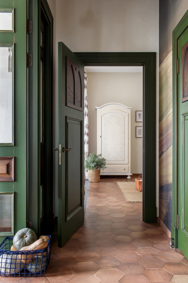This is an example of a mid-sized mediterranean hallway in Other with beige walls, ceramic floors and brown floor.