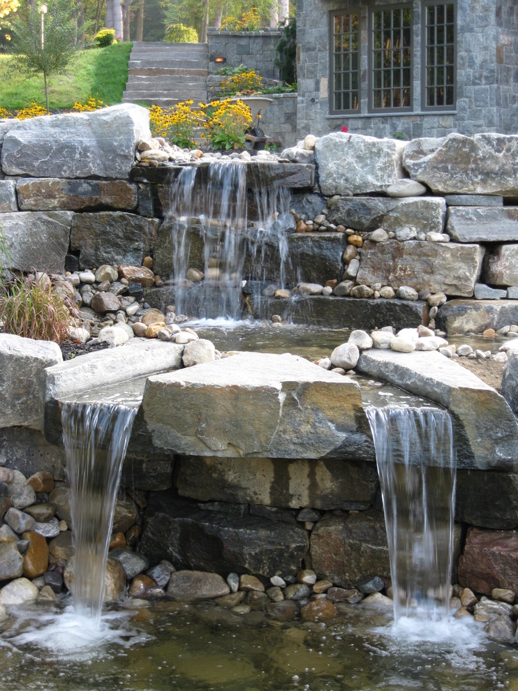 Photo of a large arts and crafts front yard partial sun garden in Burlington with a water feature and natural stone pavers.