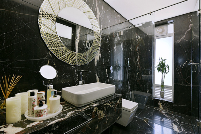 Design ideas for a small contemporary bathroom in Mumbai with flat-panel cabinets, a wall-mount toilet, black tile, black walls, marble floors, a console sink and marble benchtops.