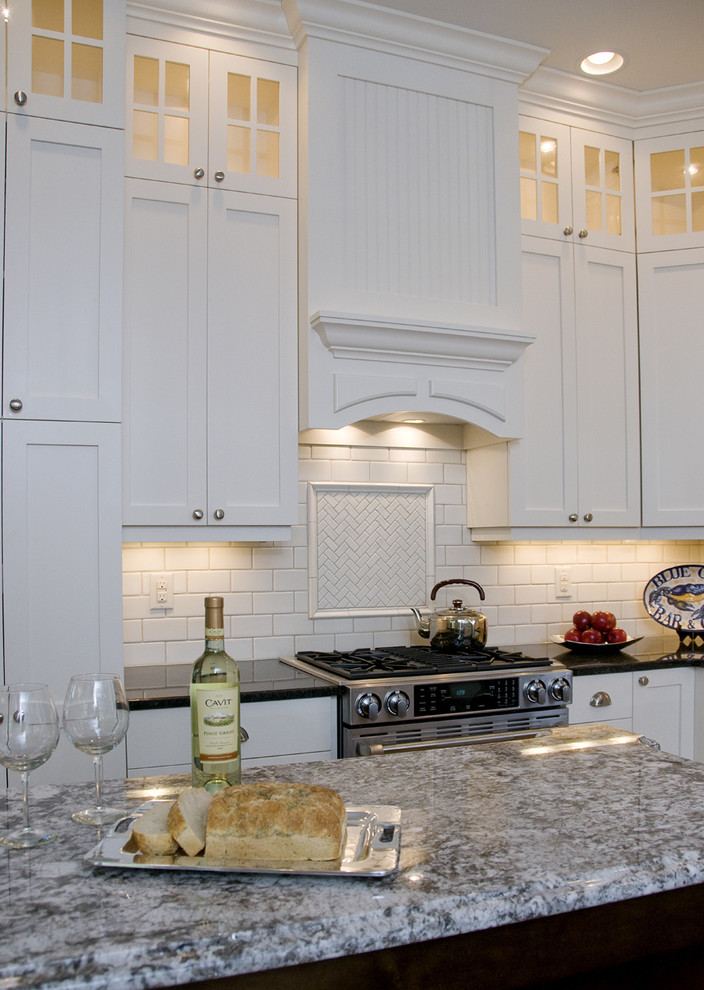 Inspiration for a traditional u-shaped eat-in kitchen in Raleigh with an undermount sink, shaker cabinets, white cabinets, granite benchtops, white splashback, subway tile splashback and stainless steel appliances.