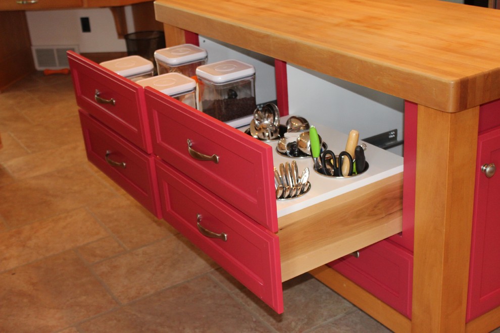 This is an example of a small traditional eat-in kitchen in Milwaukee with recessed-panel cabinets, red cabinets, wood benchtops, stainless steel appliances, ceramic floors and with island.