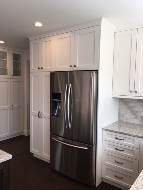 Open concept kitchen - large transitional dark wood floor and brown floor open concept kitchen idea in Seattle with an undermount sink, shaker cabinets, white cabinets, quartz countertops, multicolored backsplash, glass tile backsplash, stainless steel appliances and an island