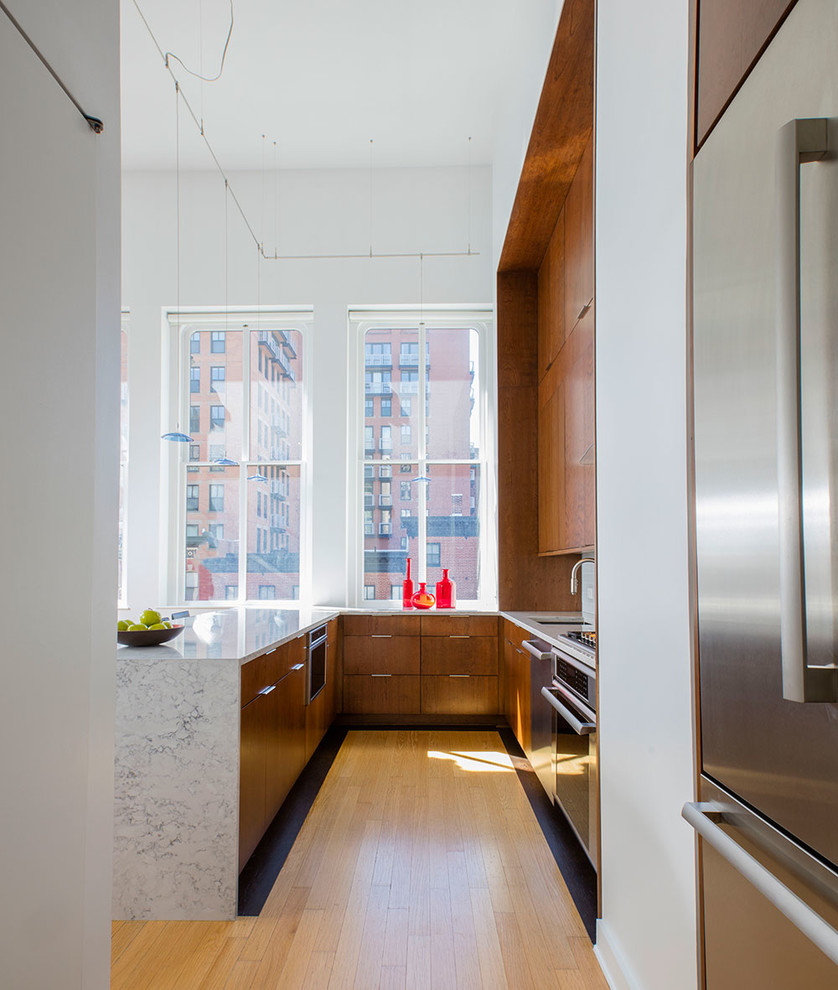 Mid-sized contemporary u-shaped eat-in kitchen in DC Metro with an undermount sink, flat-panel cabinets, dark wood cabinets, quartz benchtops, white splashback, glass tile splashback, stainless steel appliances, light hardwood floors and a peninsula.