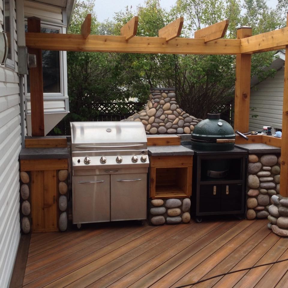 Large eclectic backyard outdoor kitchen deck photo in Calgary with a pergola
