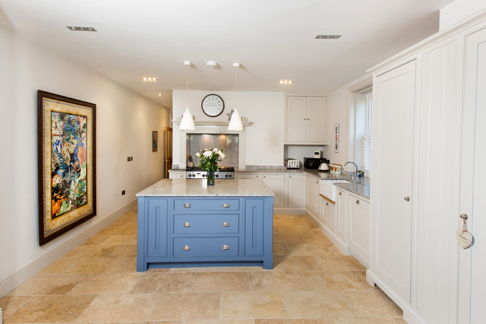 Photo of a traditional l-shaped kitchen in Other with a farmhouse sink, shaker cabinets, white cabinets, stainless steel appliances and with island.