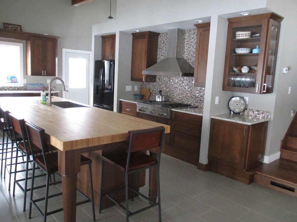 Eat-in kitchen - mid-sized transitional galley ceramic tile eat-in kitchen idea with a drop-in sink, shaker cabinets, dark wood cabinets, quartz countertops, stainless steel appliances, an island, metallic backsplash and mosaic tile backsplash