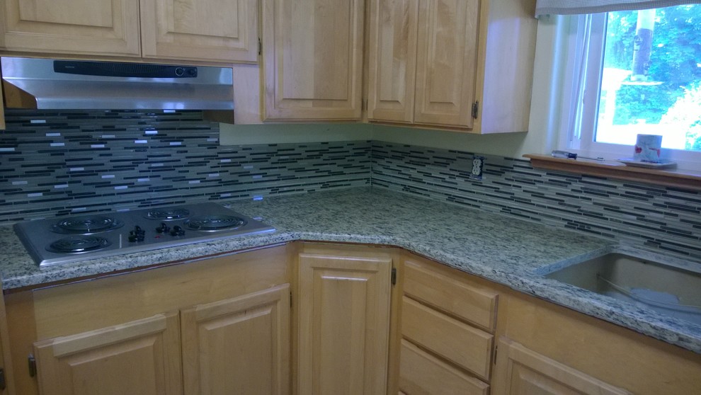 L-shaped eat-in kitchen photo in Seattle with light wood cabinets, granite countertops, glass tile backsplash and stainless steel appliances