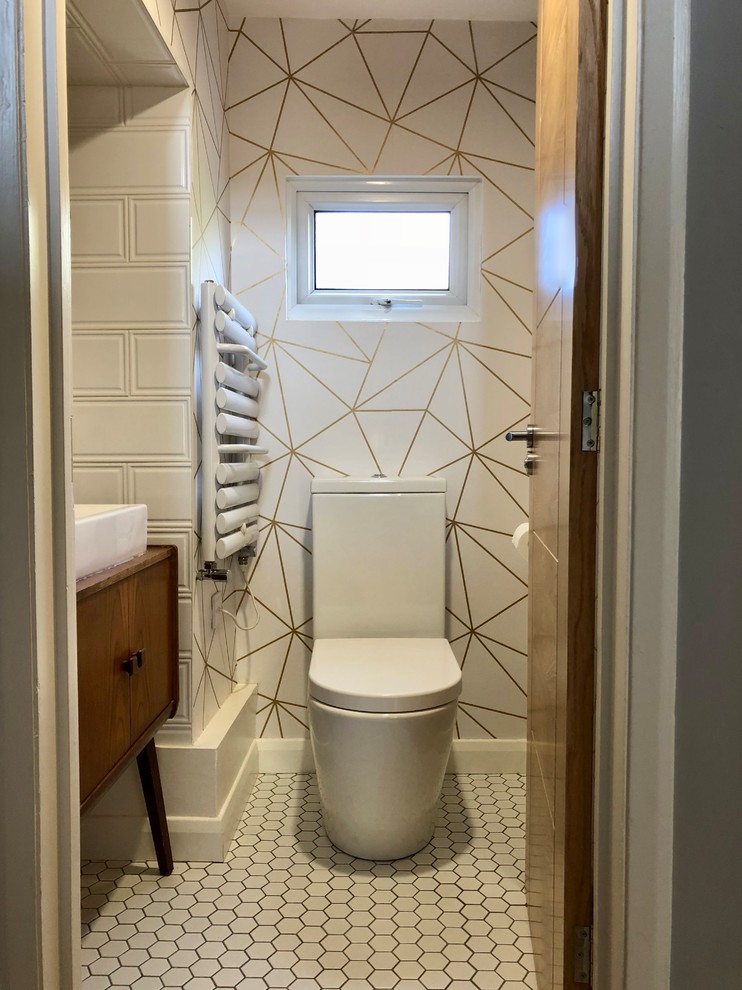 Photo of a small midcentury powder room in Other with furniture-like cabinets, dark wood cabinets, a two-piece toilet, white tile, ceramic tile, multi-coloured walls, ceramic floors, a vessel sink, wood benchtops and white floor.