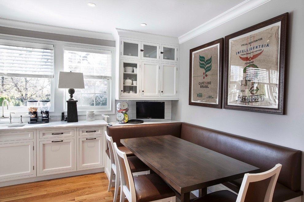Transitional eat-in kitchen in New York with an undermount sink, recessed-panel cabinets, white cabinets, white splashback and subway tile splashback.