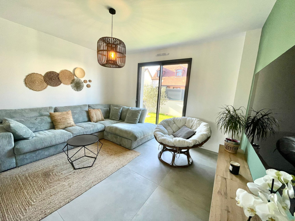 На фото: открытая гостиная комната среднего размера в современном стиле с зелеными стенами, полом из керамической плитки, печью-буржуйкой, телевизором на стене, серым полом и кессонным потолком