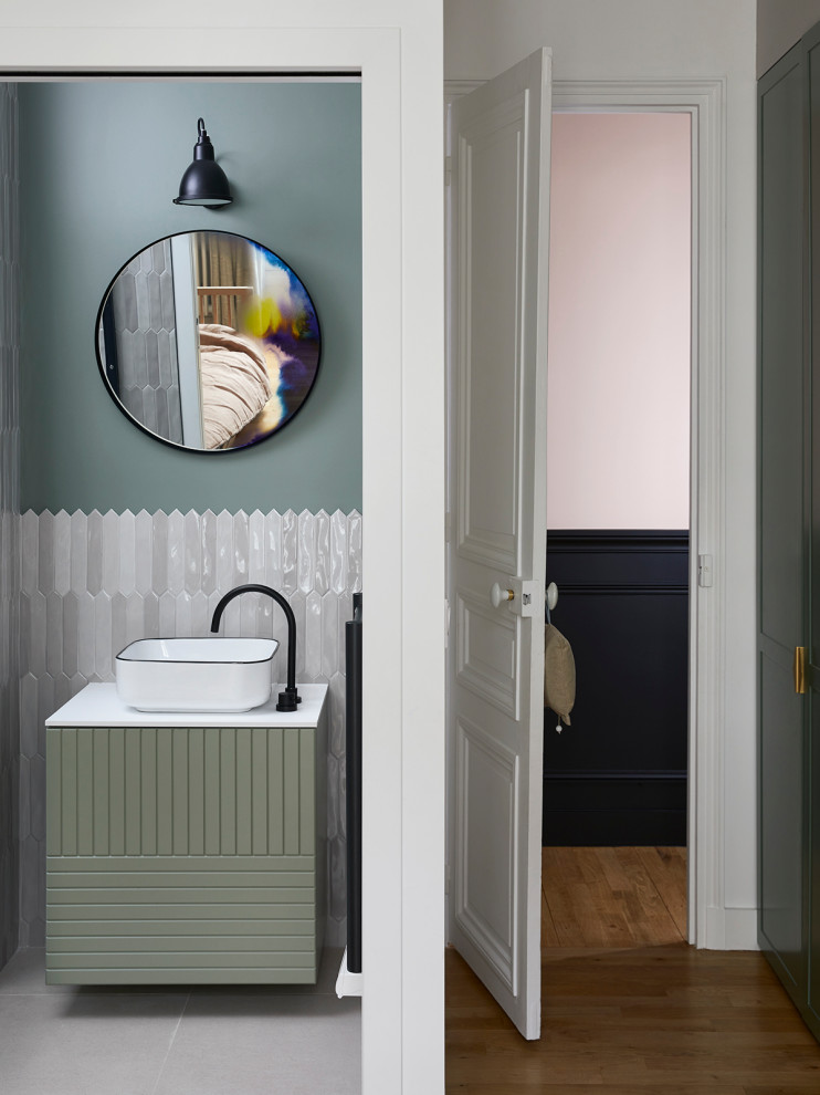 Photo of a small contemporary family bathroom in Paris with beaded cabinets, green cabinets, an alcove shower, beige tiles, terracotta tiles, green walls, ceramic flooring, a built-in sink, solid surface worktops, beige floors, a sliding door, white worktops, a single sink and a floating vanity unit.