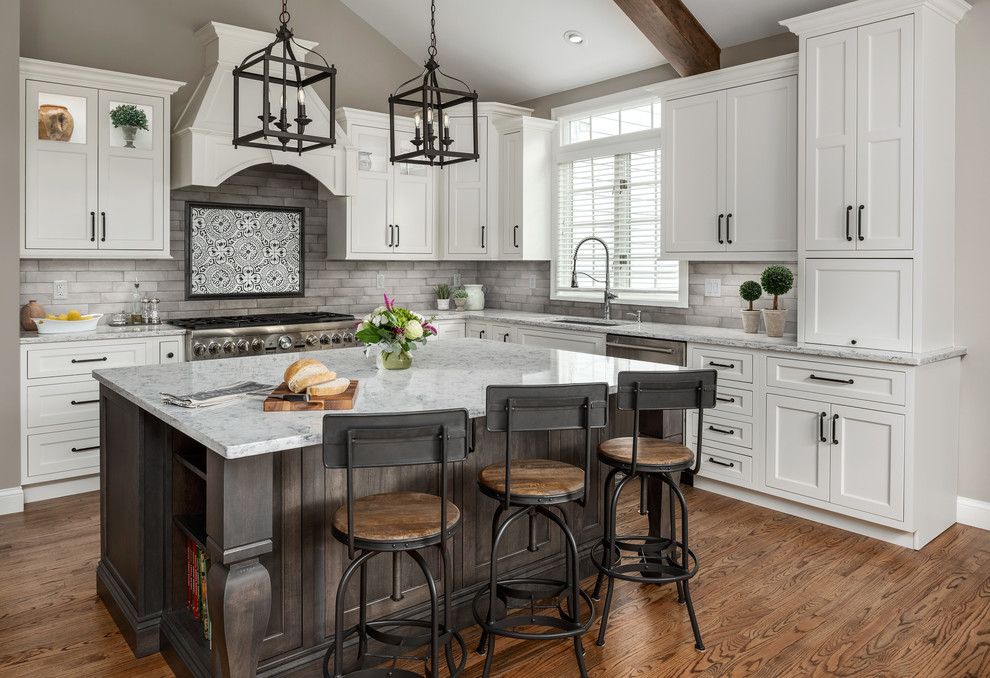 Eat-in kitchen - large transitional l-shaped medium tone wood floor and brown floor eat-in kitchen idea in St Louis with an undermount sink, flat-panel cabinets, white cabinets, quartz countertops, gray backsplash, ceramic backsplash, stainless steel appliances, an island and white countertops