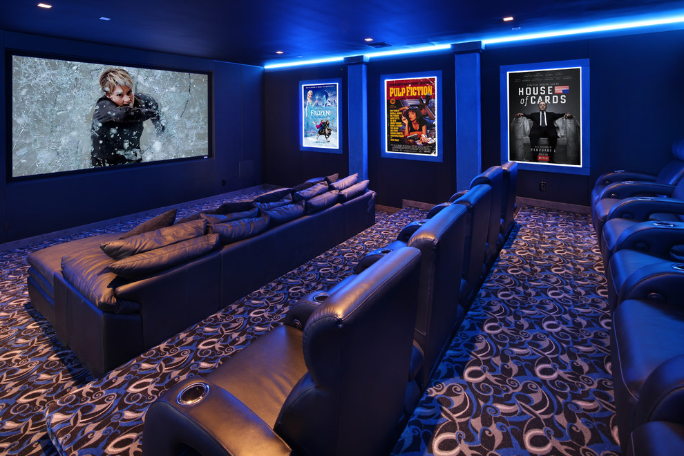 Photo of a large contemporary enclosed home theatre in Orange County with blue walls, carpet, a projector screen and multi-coloured floor.