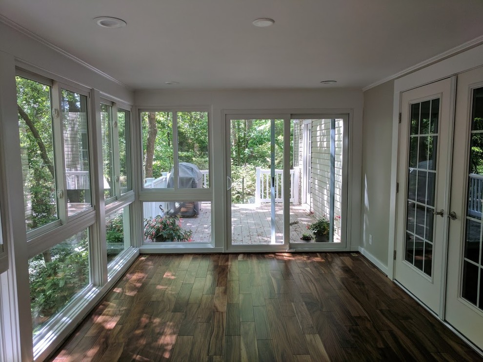 Mid-sized traditional sunroom in Huntington with laminate floors, a standard ceiling and brown floor.