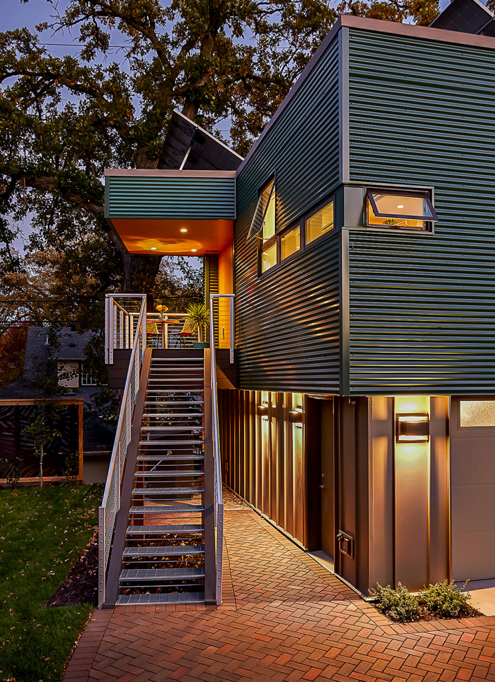 Inspiration för ett litet funkis grönt hus, med två våningar, metallfasad och platt tak