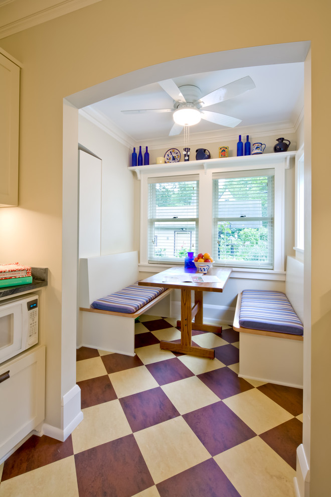 Photo of a mid-sized traditional galley separate kitchen in Minneapolis with recessed-panel cabinets, white cabinets, marble benchtops, white splashback, white appliances and linoleum floors.