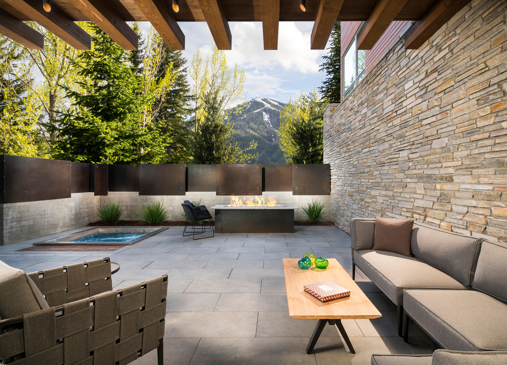 Large country side yard patio in Salt Lake City with a fire feature, a roof extension and concrete pavers.