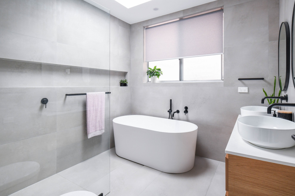 Design ideas for a mid-sized modern master bathroom in Sydney with flat-panel cabinets, brown cabinets, a freestanding tub, an open shower, a one-piece toilet, gray tile, ceramic tile, grey walls, ceramic floors, a drop-in sink, engineered quartz benchtops, grey floor, an open shower, yellow benchtops, a niche, a floating vanity and a double vanity.