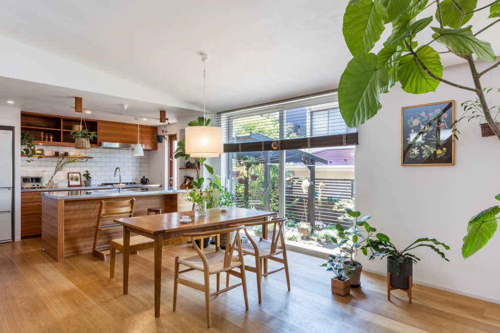 Mid-sized asian galley eat-in kitchen in Other with an undermount sink, flat-panel cabinets, medium wood cabinets, white splashback, subway tile splashback, medium hardwood floors, a peninsula, beige floor and grey benchtop.