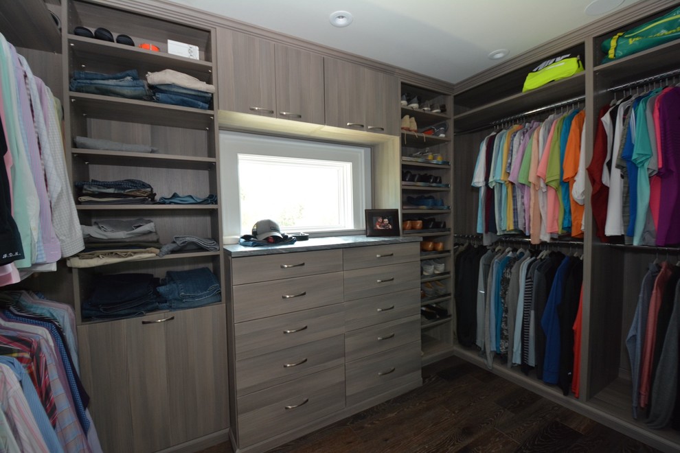 Photo of a mid-sized contemporary men's walk-in wardrobe in Tampa with flat-panel cabinets, medium wood cabinets and dark hardwood floors.