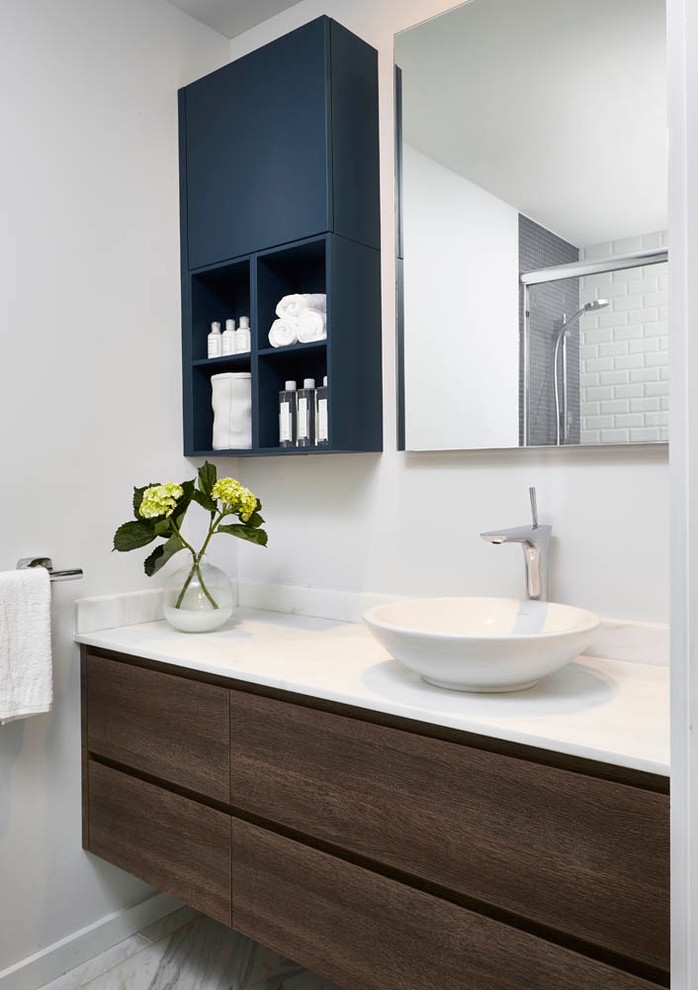 Photo of a small contemporary bathroom in Detroit with a vessel sink, flat-panel cabinets, dark wood cabinets, engineered quartz benchtops, white walls and marble floors.