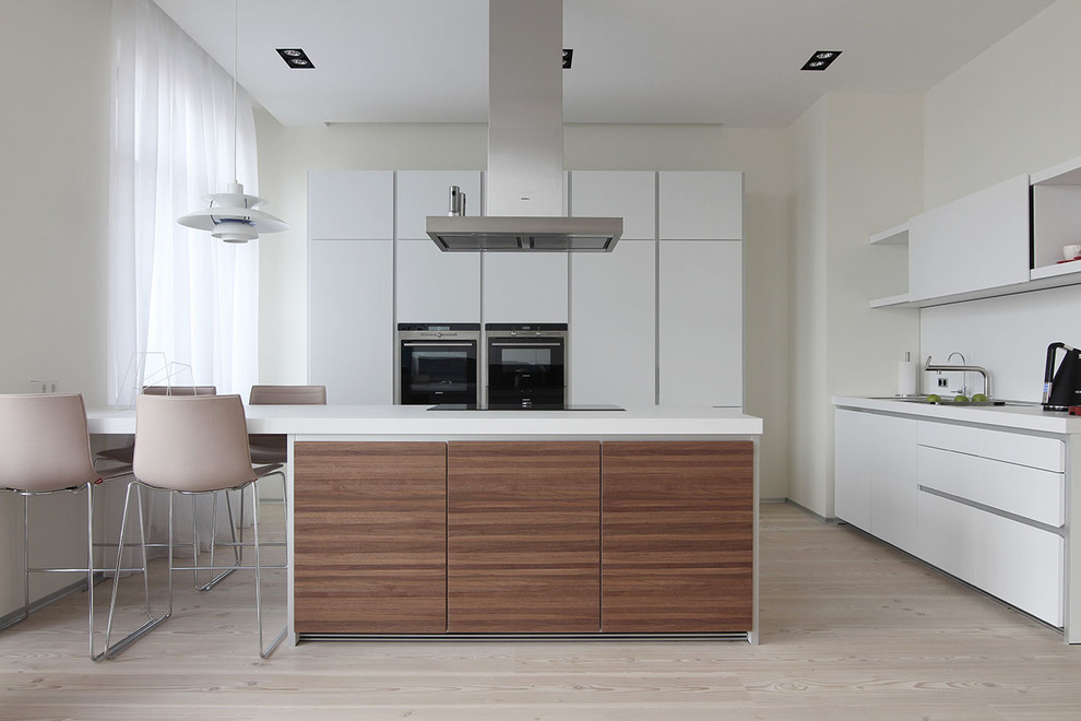 Design ideas for a large contemporary u-shaped open plan kitchen in Saint Petersburg with an undermount sink, flat-panel cabinets, white cabinets, white splashback, stainless steel appliances, with island and beige floor.