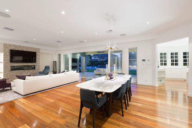 Photo of a modern open plan dining in Sydney with white walls, medium hardwood floors and a ribbon fireplace.